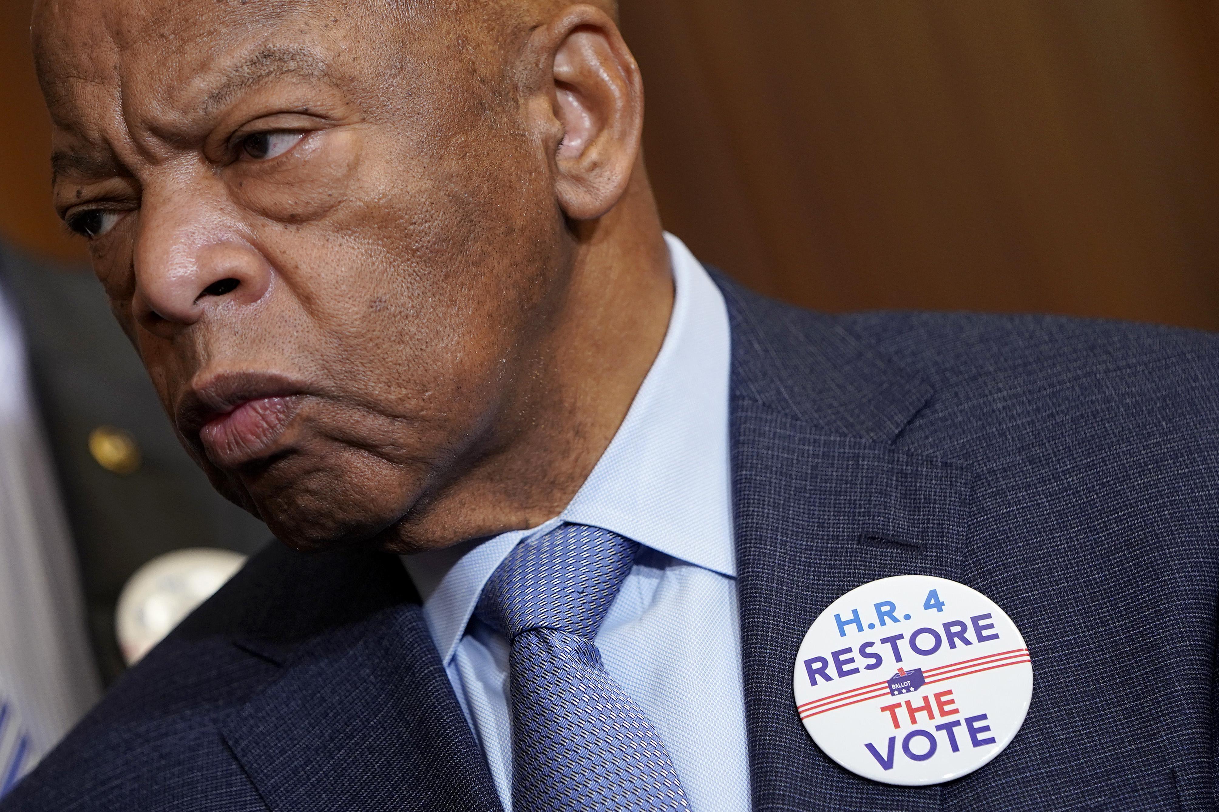 Rep. John Lewis wearing a pin that says H.R. 4 RESTORE THE VOTE