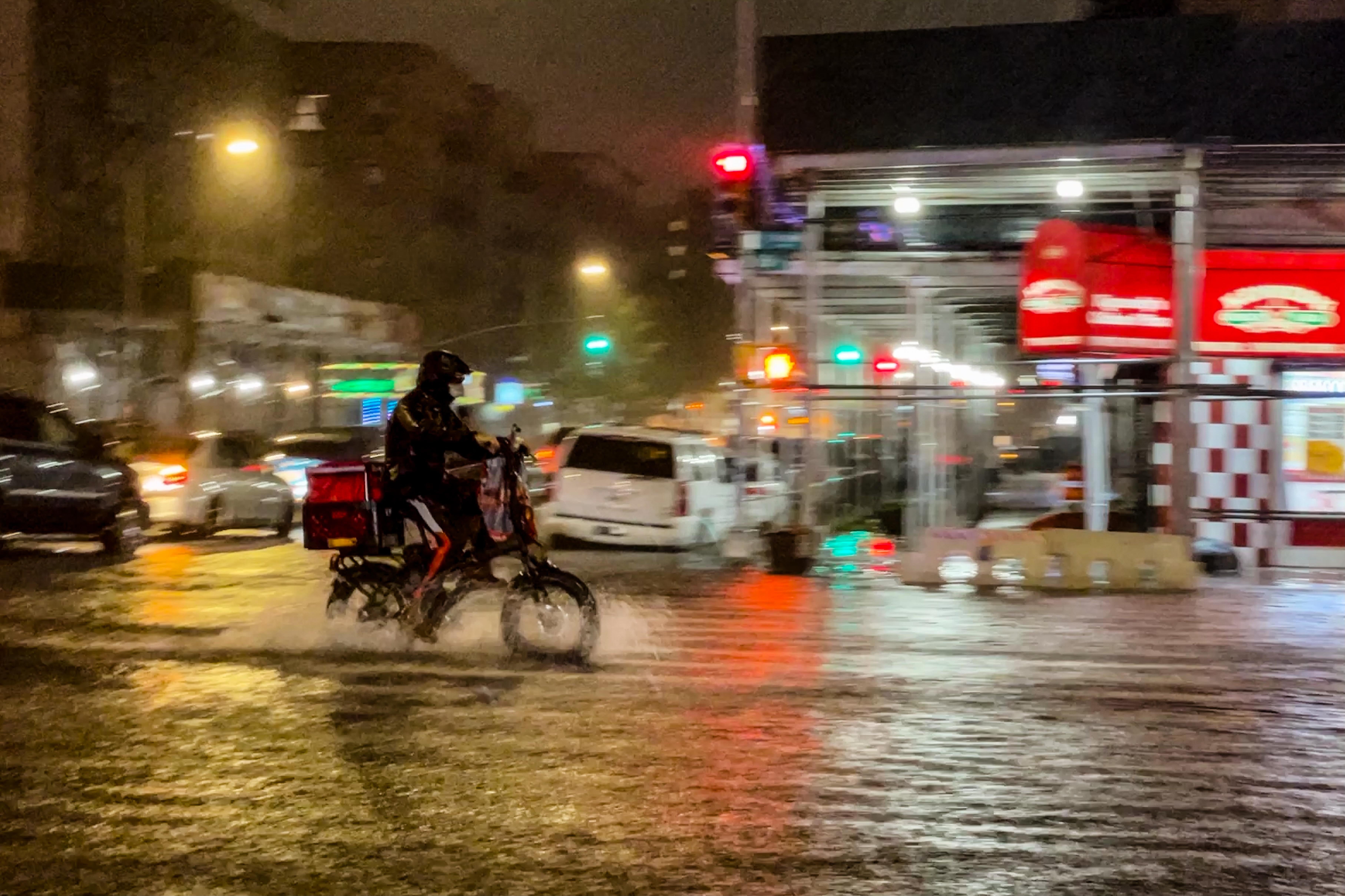A delivery worker makes their way in the rainfall from Hurricane Ida during a flood on Intervale Avenue on September 1, 2021, in the Bronx borough of New York City. 