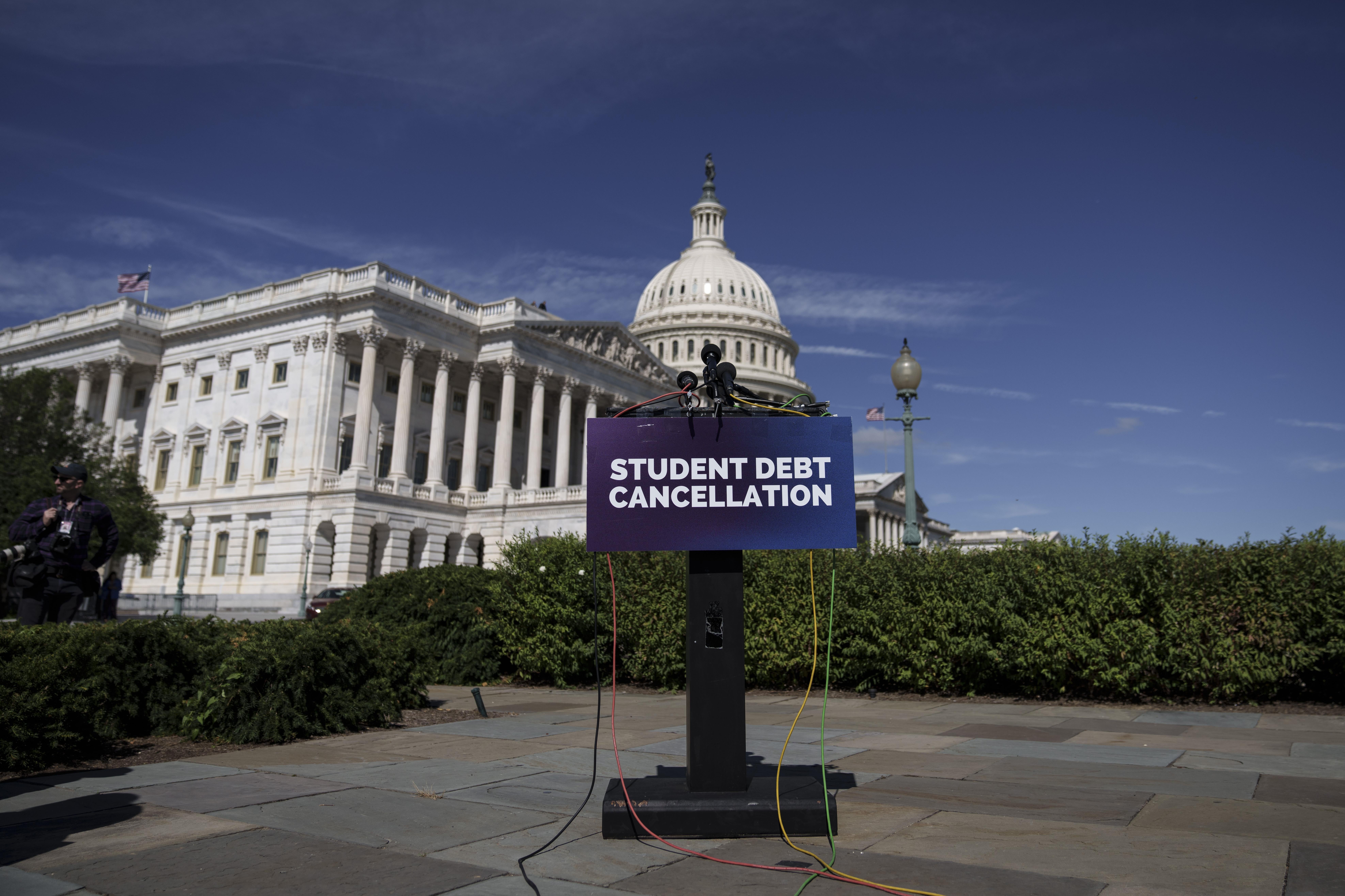 A sign in front of the U.S. Capitol that says "student debt cancellation."