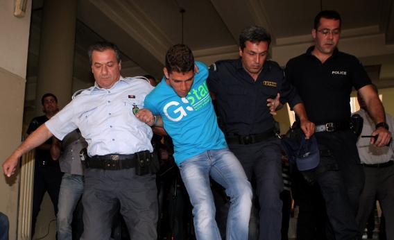 Police officers drag to prosecutor a 20-year-old Dutch entertainer in Herakleion, Crete, on May 16, 2013.