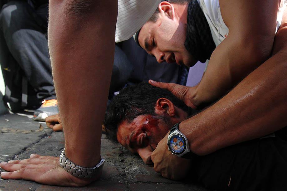 A fallen protester receives help after gun shots were heard during an anti-government rally in Caracas.