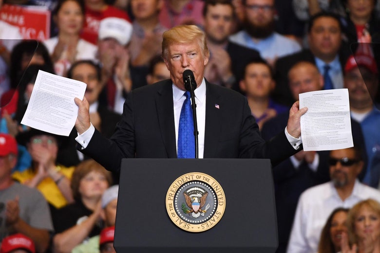 President Donald Trump holds up two sheets of paper while speaking behind the podium during a campaign rally at the Las Vegas Convention Center on Sept. 20, 2018.