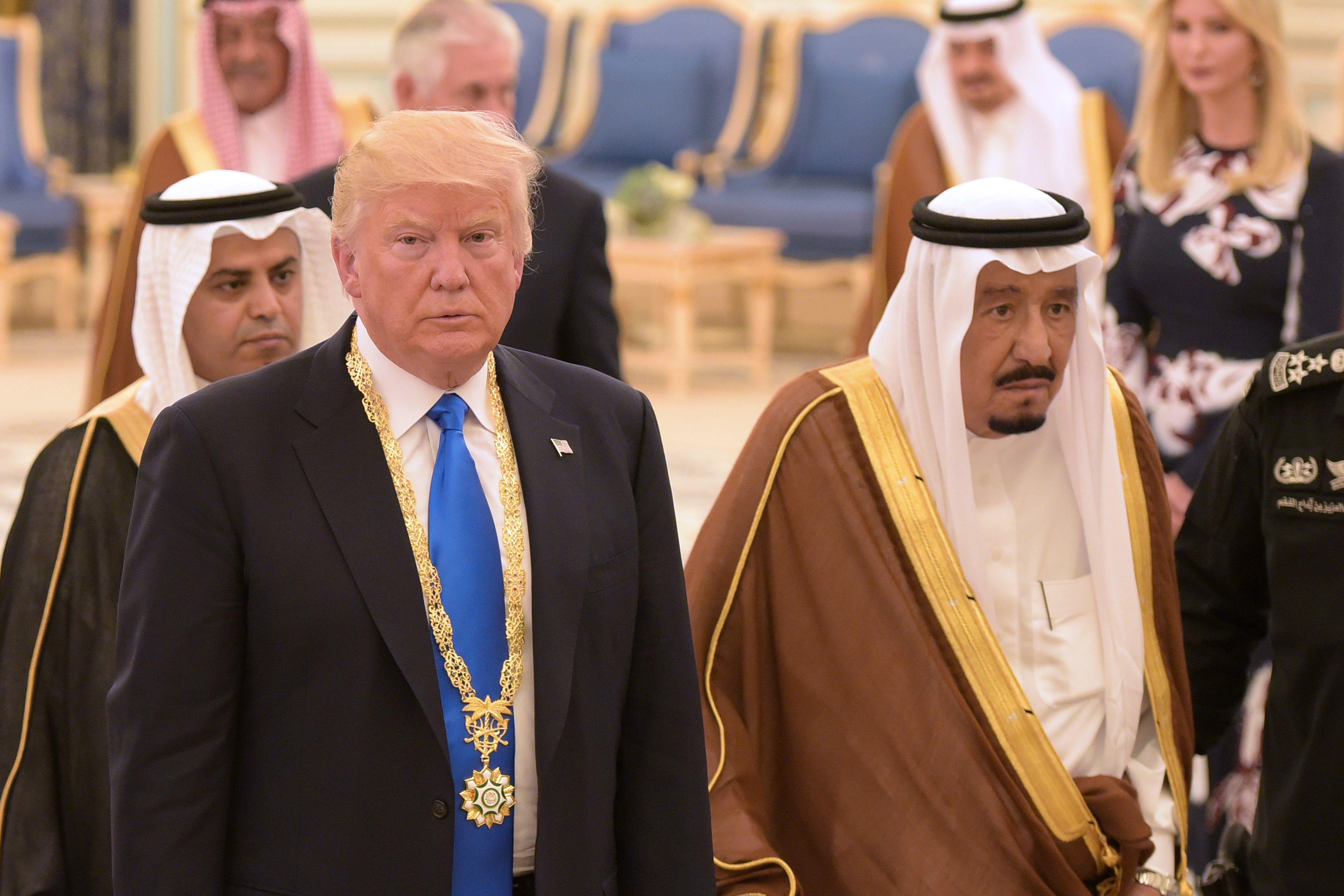 Donald Trump walking with King Salman, with Ivanka Trump and Saudi officials in the background.