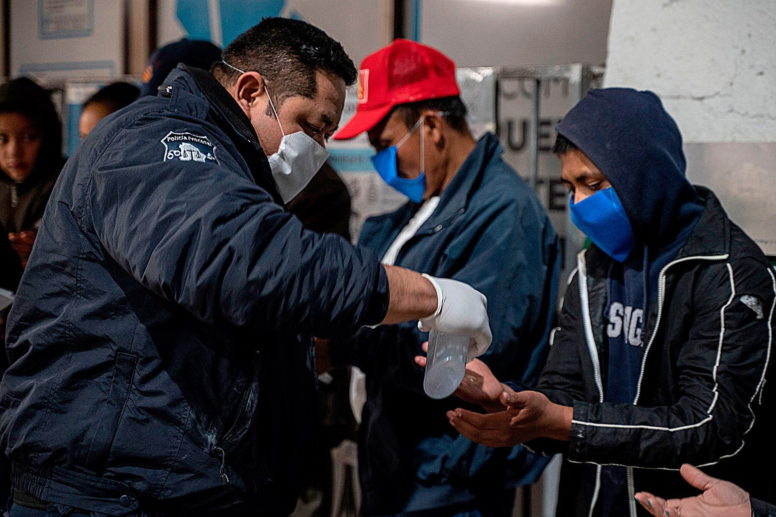 Chihuahua State Police give out hand sanitizer to migrants on April 6 at the Paso del Norte International Bridge in Ciudad Juárez in Chihuahua, Mexico.