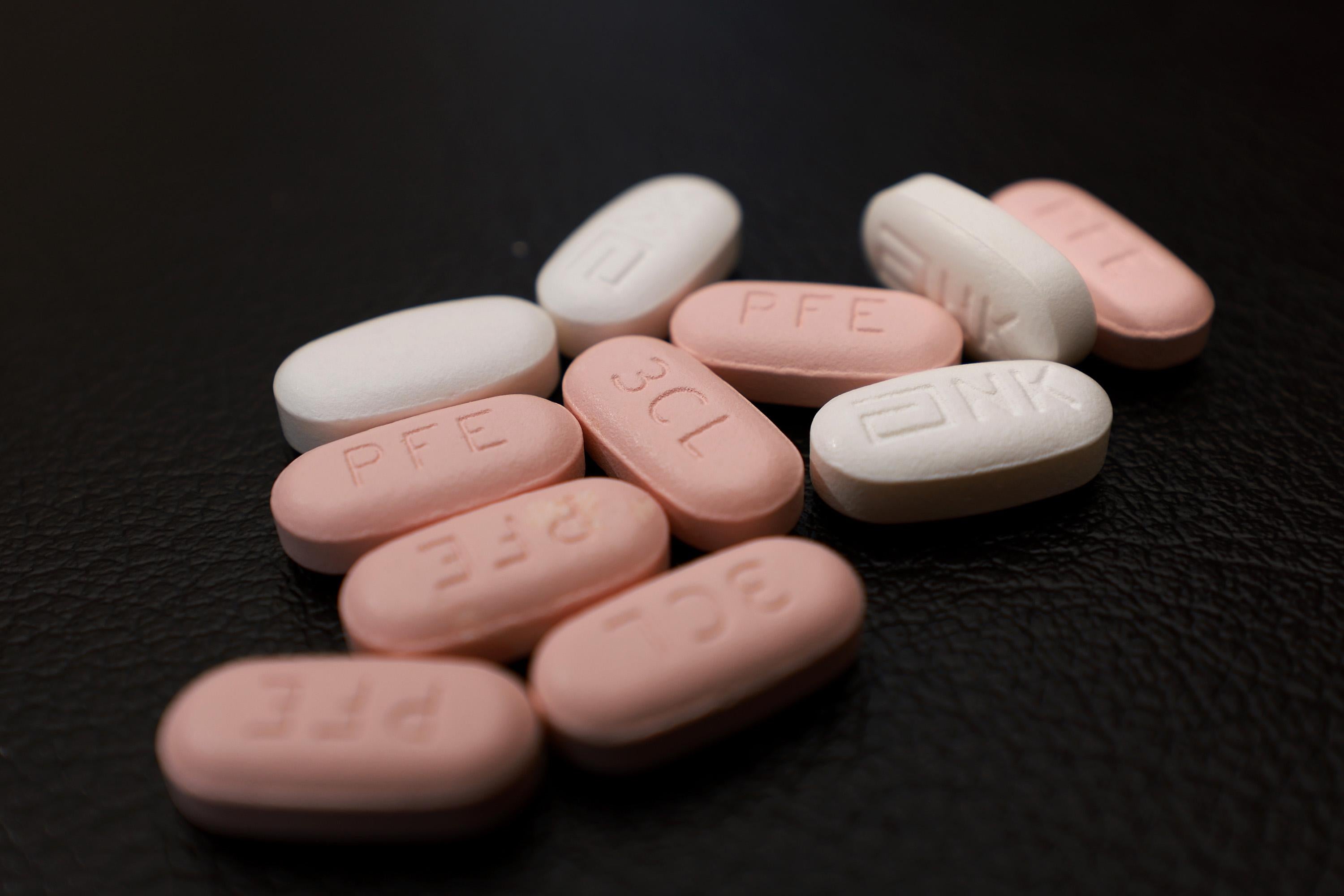 A bunch of pink pills, and white pills. They are long and oval-shaped, and look like they'd be a little tough to swallow. 