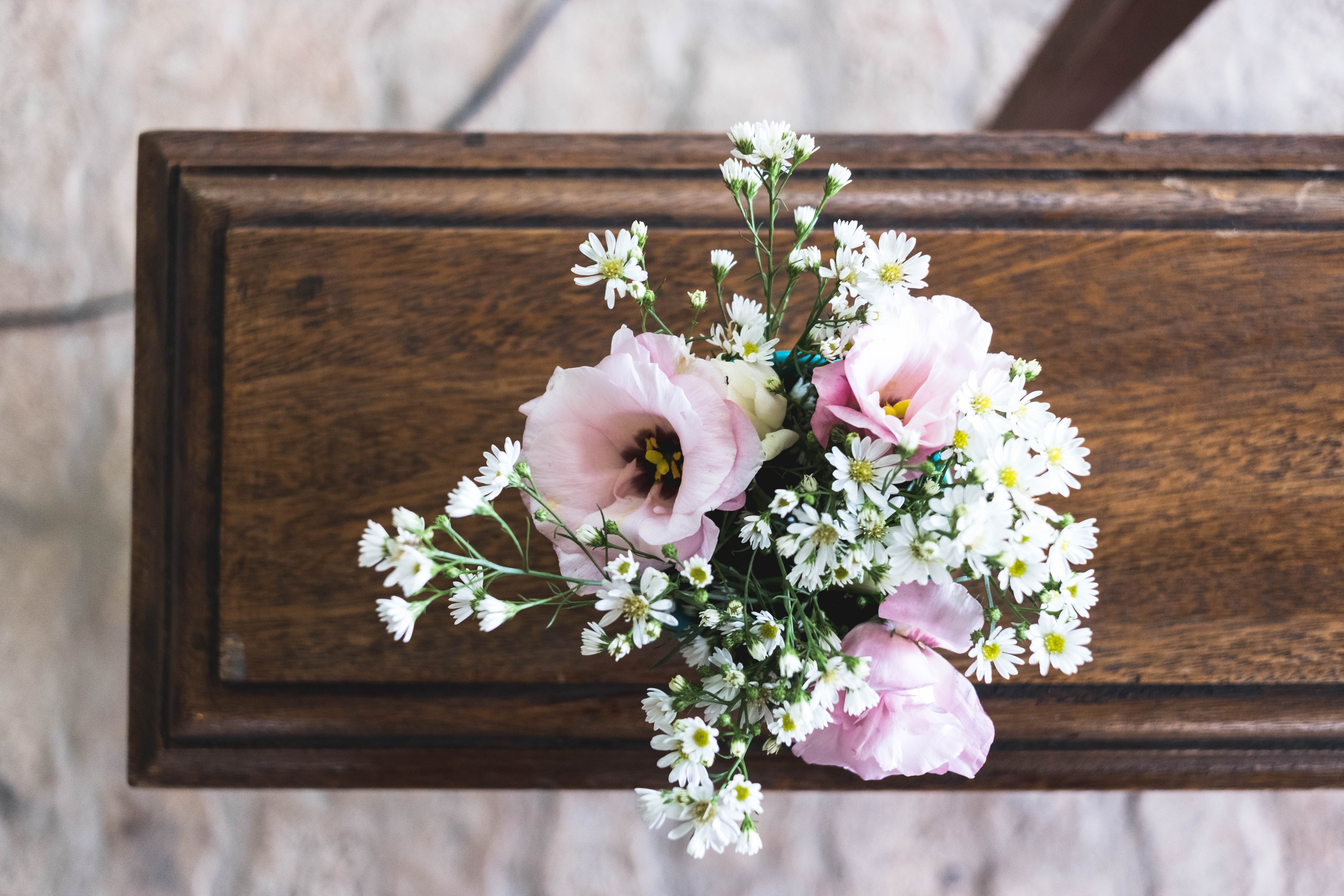 Flowers sit on top of a wooden casket.