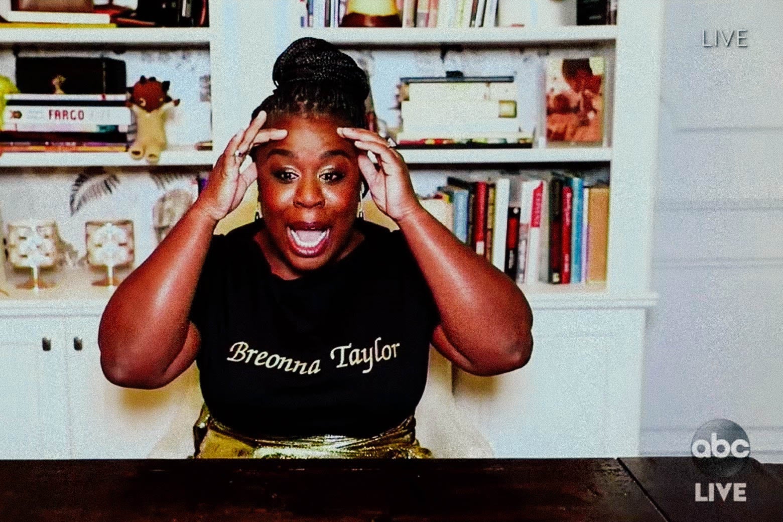 Uzo Aduba in front of a bookcase.