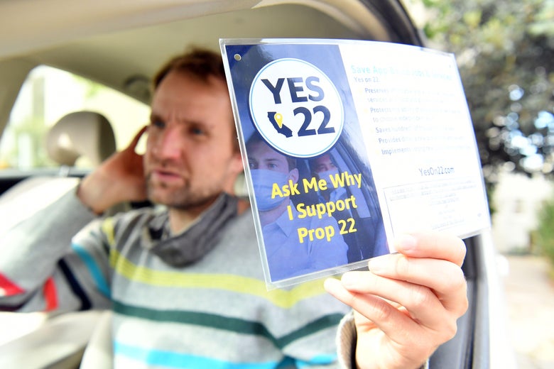 An Uber driver holds a Yes on 22 sign. 