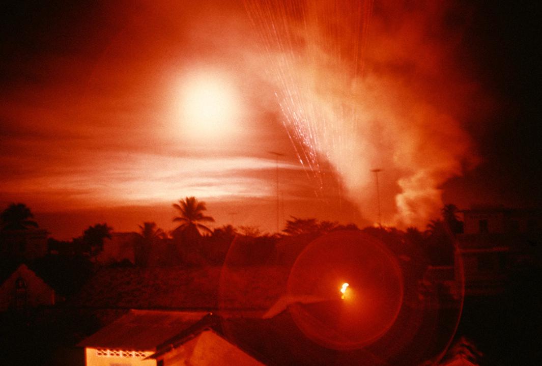 Tet Offensive, Saigon. Overhead a helicopter gunship fires 5,000 bullets a minute. Every Every fifth bullet is a red tracer that helps direct fire to its target.Vietnam, February 1968