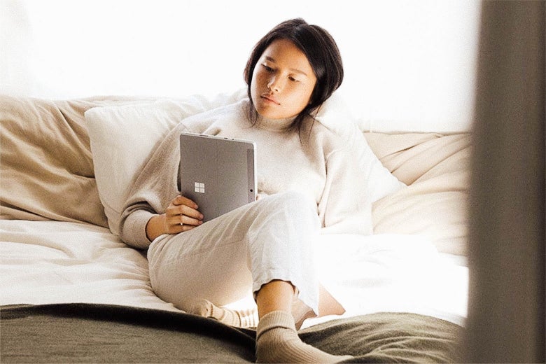 A woman in bed with her Microsoft Surface Pro.