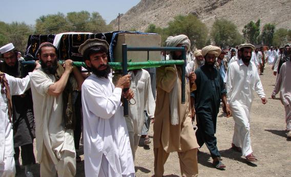 Pakistani tribesmen carry the coffin of a person allegedly killed in a 2011 U.S. drone attack. They claim that innocent civilians died.