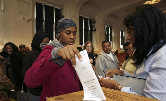 Voter Mirenda Watkins casts a ballot containing her vote for the Presidential Election