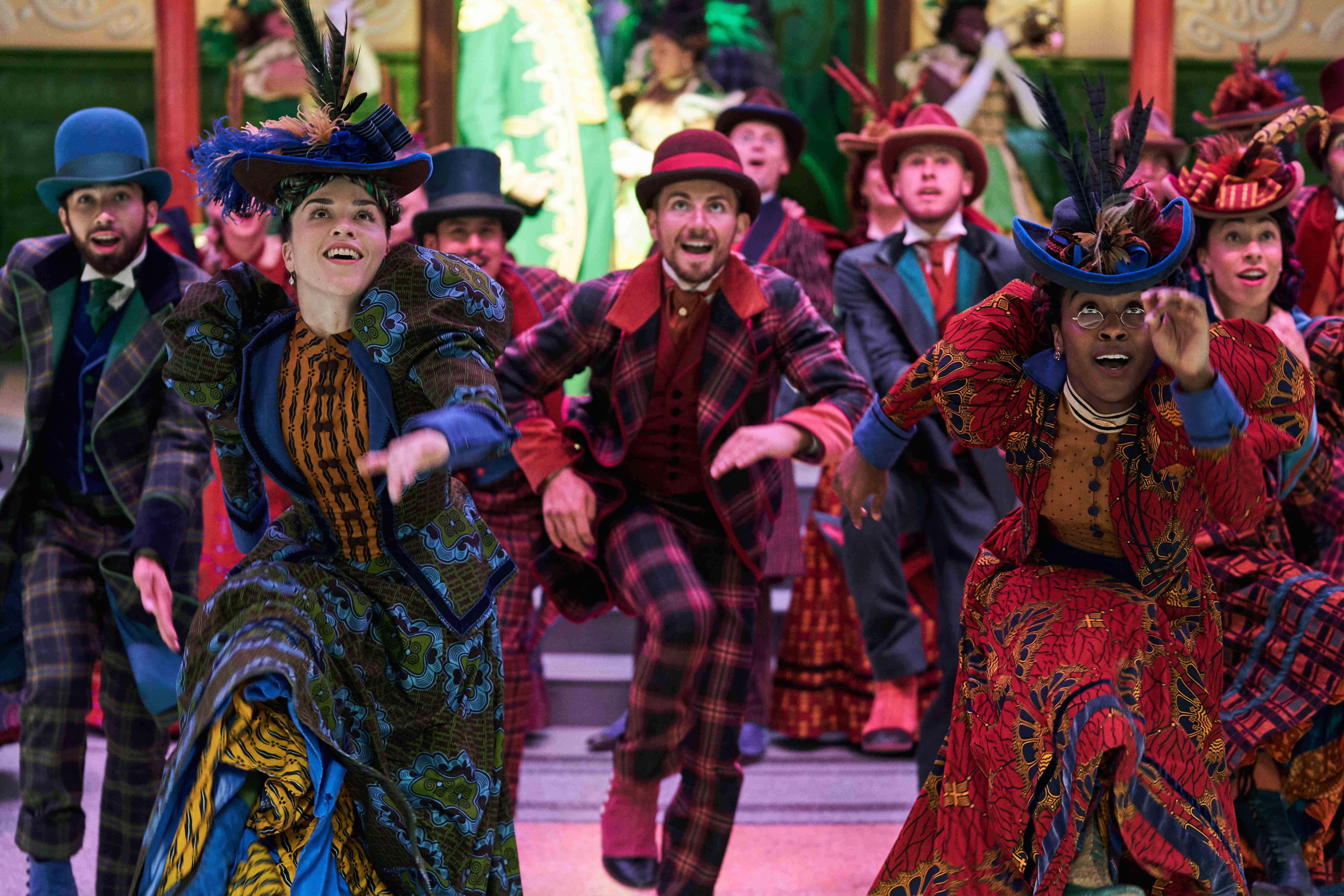 A group of people in brightly colored costumes dance.