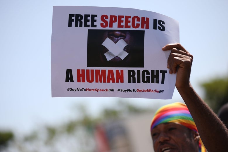 A protester holds a placard that reads "Free Speech Is a Human Right."
