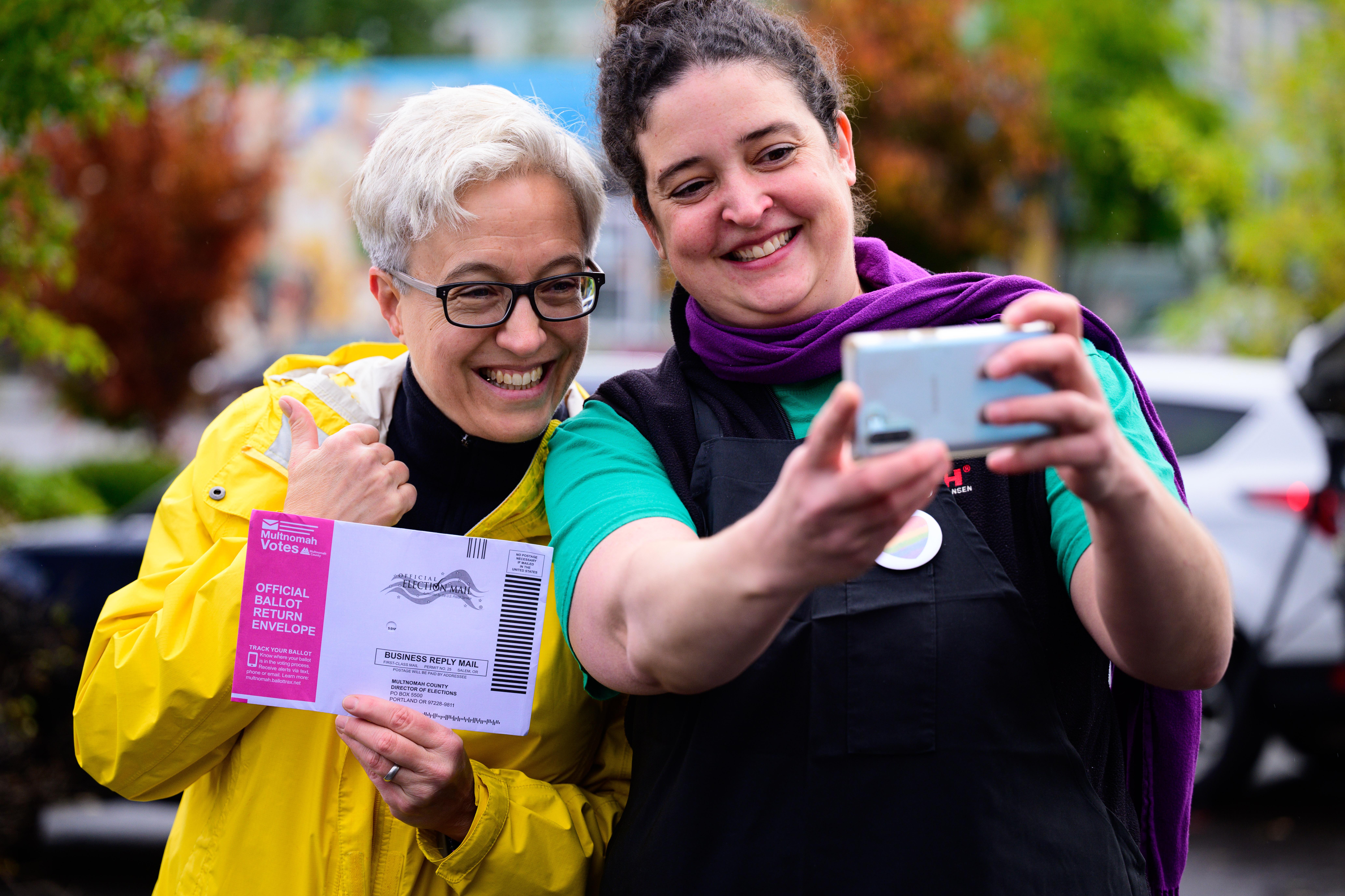 Two people taking a ballot selfie