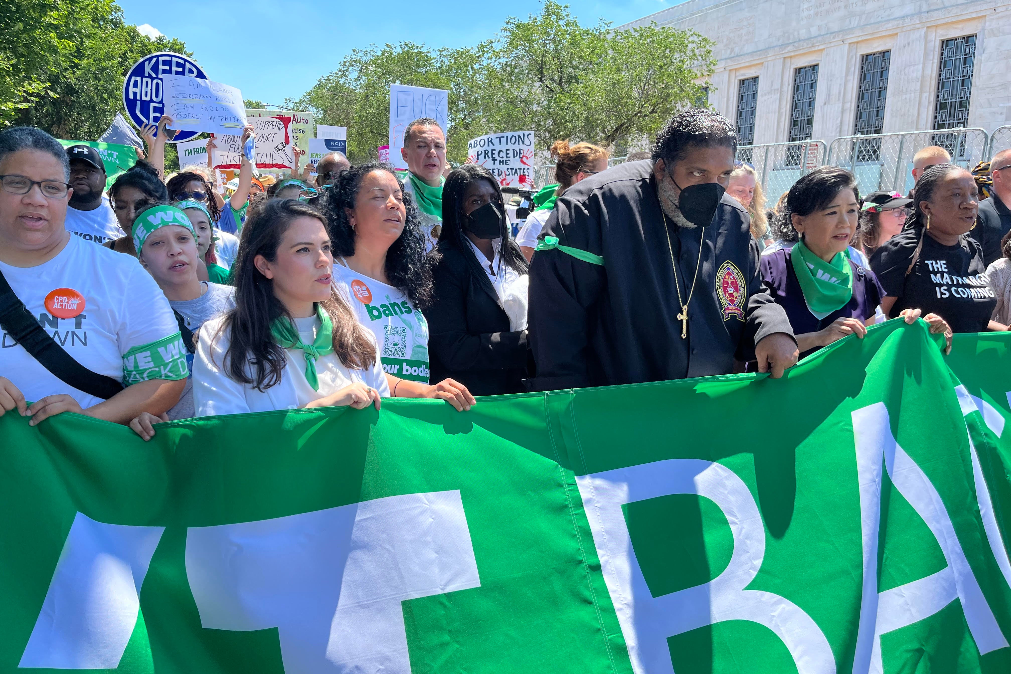 A crowd of protestors marching, holding pro-choice banners and signs