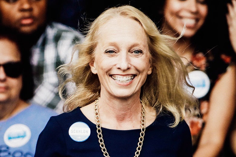 Mary Gay Scanlon smiles in front of a crowd of sticker-wearing supporters.