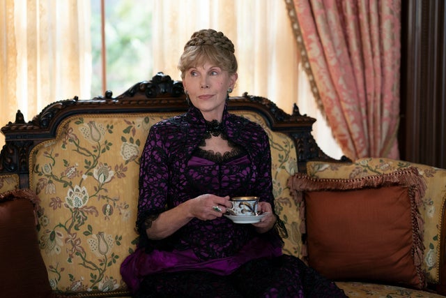 Christine Baranski sitting in a parlor holding a cup of tea in a scene from The Gilded Age