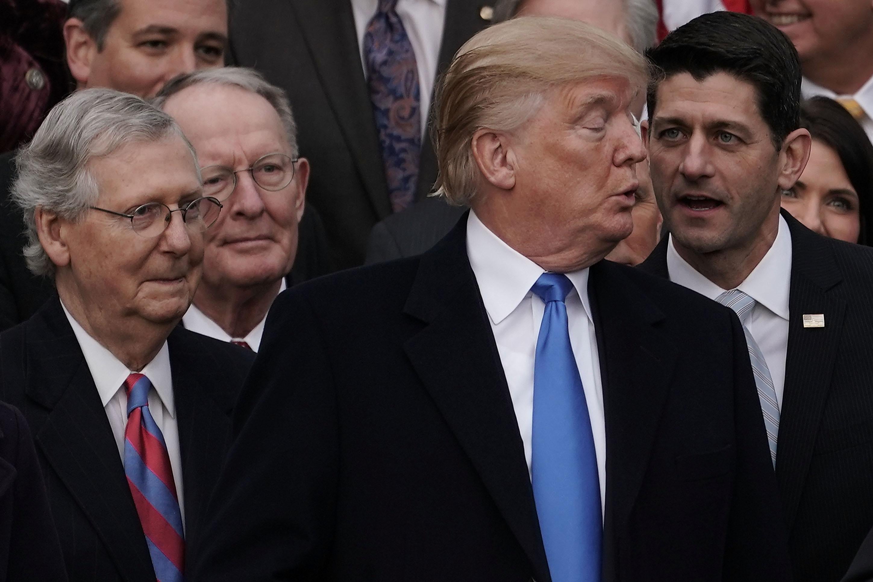 WASHINGTON, DC - DECEMBER 20:  U.S. Speaker of the House Rep. Paul Ryan (R-WI) talks to President Donald Trump (3rd L) as Senate Majority Leader Sen. Mitch McConnell (R-KY), and Sen. Lamar Alexander (R-TN) (2nd L) look on during an event to celebrate Congress passing the Tax Cuts and Jobs Act with Republican members of the House and Senate on the South Lawn of the White House December 20, 2017 in Washington, DC. The tax bill is the first major legislative victory for the GOP-controlled Congress and Trump since he took office almost one year ago.  (Photo by Alex Wong/Getty Images)
