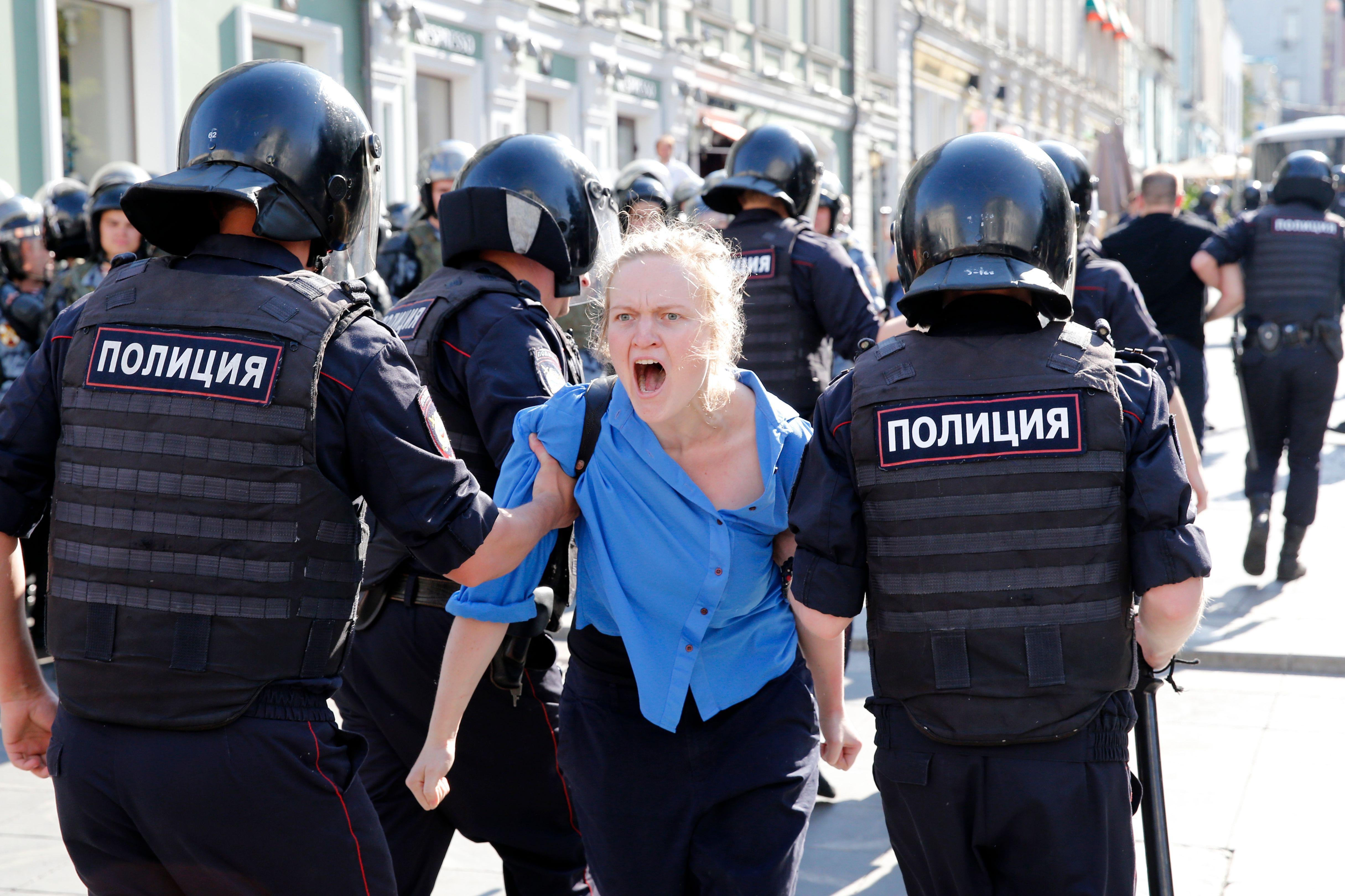 Police officers detain a protester during a rally demanding independent and opposition candidates be allowed to run for office in local election in September, in downtown Moscow on July 27, 2019. 