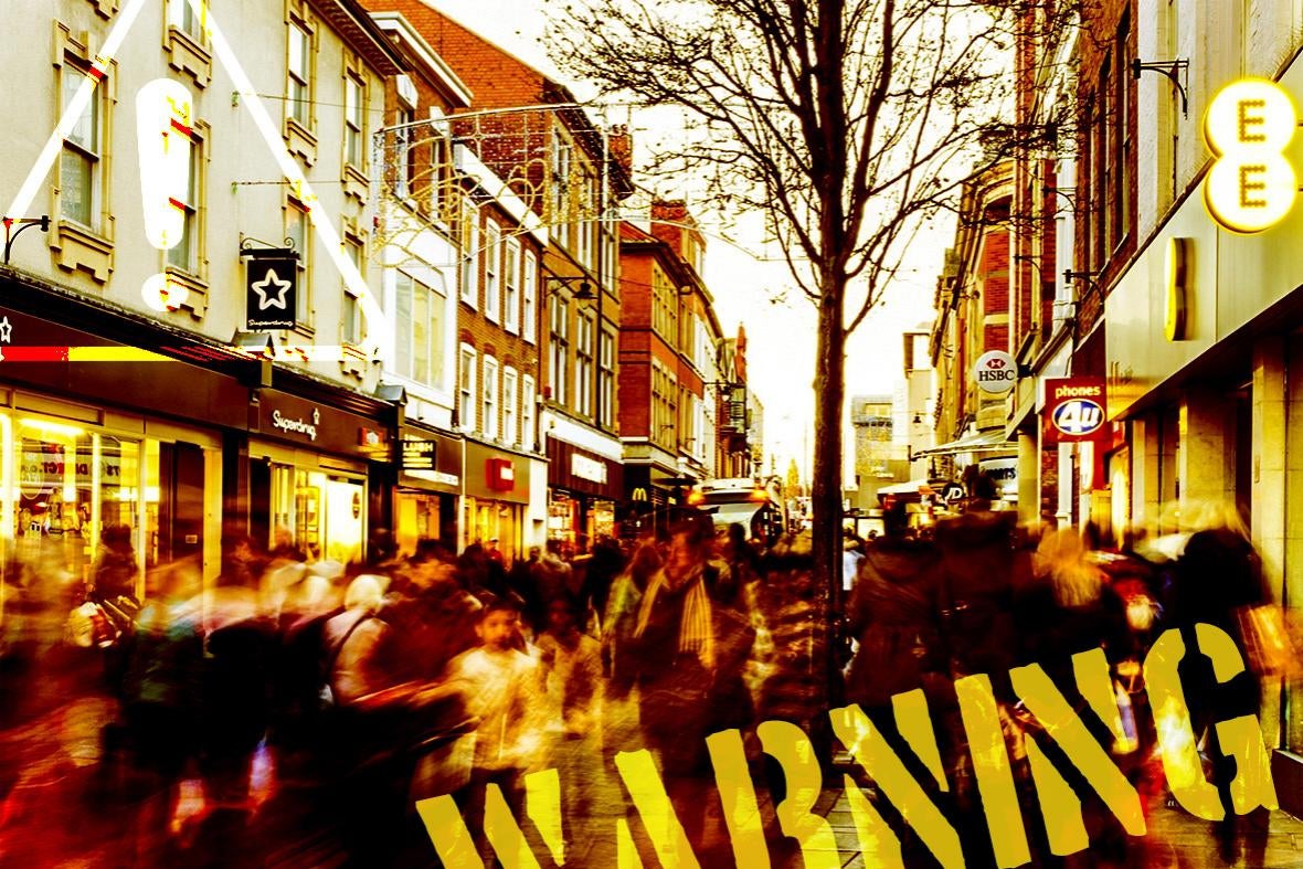 A busy commercial street with the word WARNING on it.