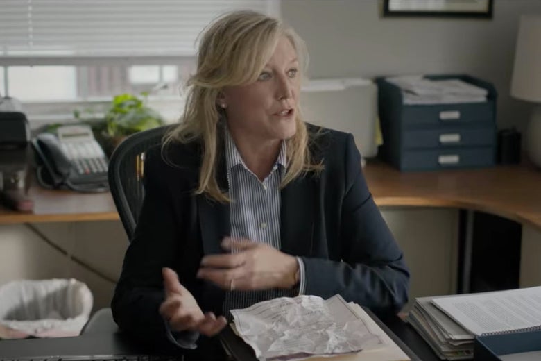 Bill's lawyer sitting behind a desk in an office.