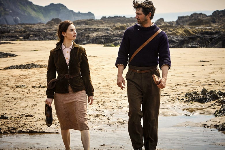 Lily James and Michiel Huisman walk on the beach in The Guernsey Literary and Potato Peel Society.