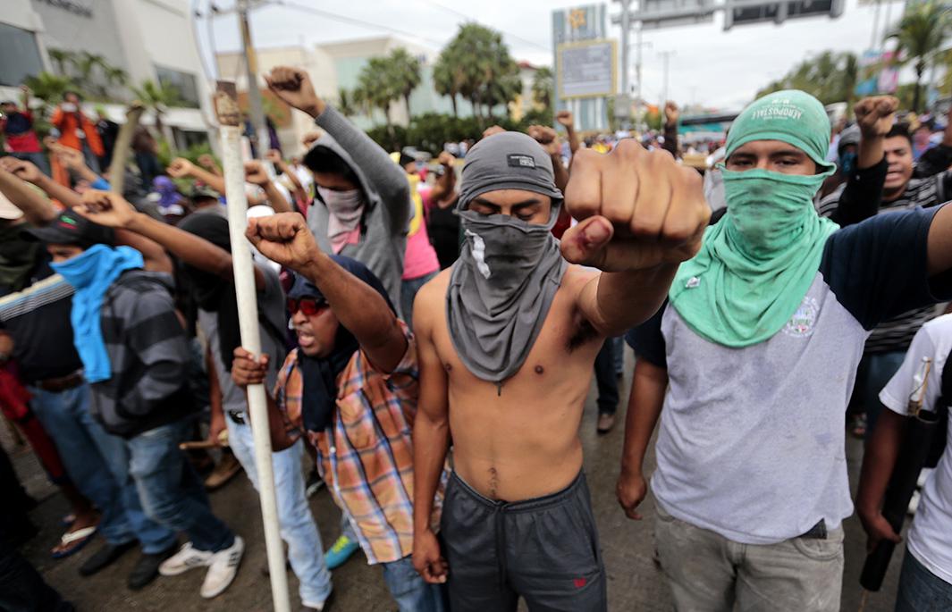 Students, farmworkers and other demonstrators confront the riot police during a protest near Acapulco in Guerrero state.