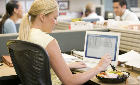 Woman eating at her desk.
