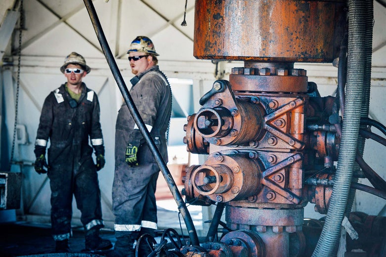 Workers chat beside a Consol Energy drilling rig.