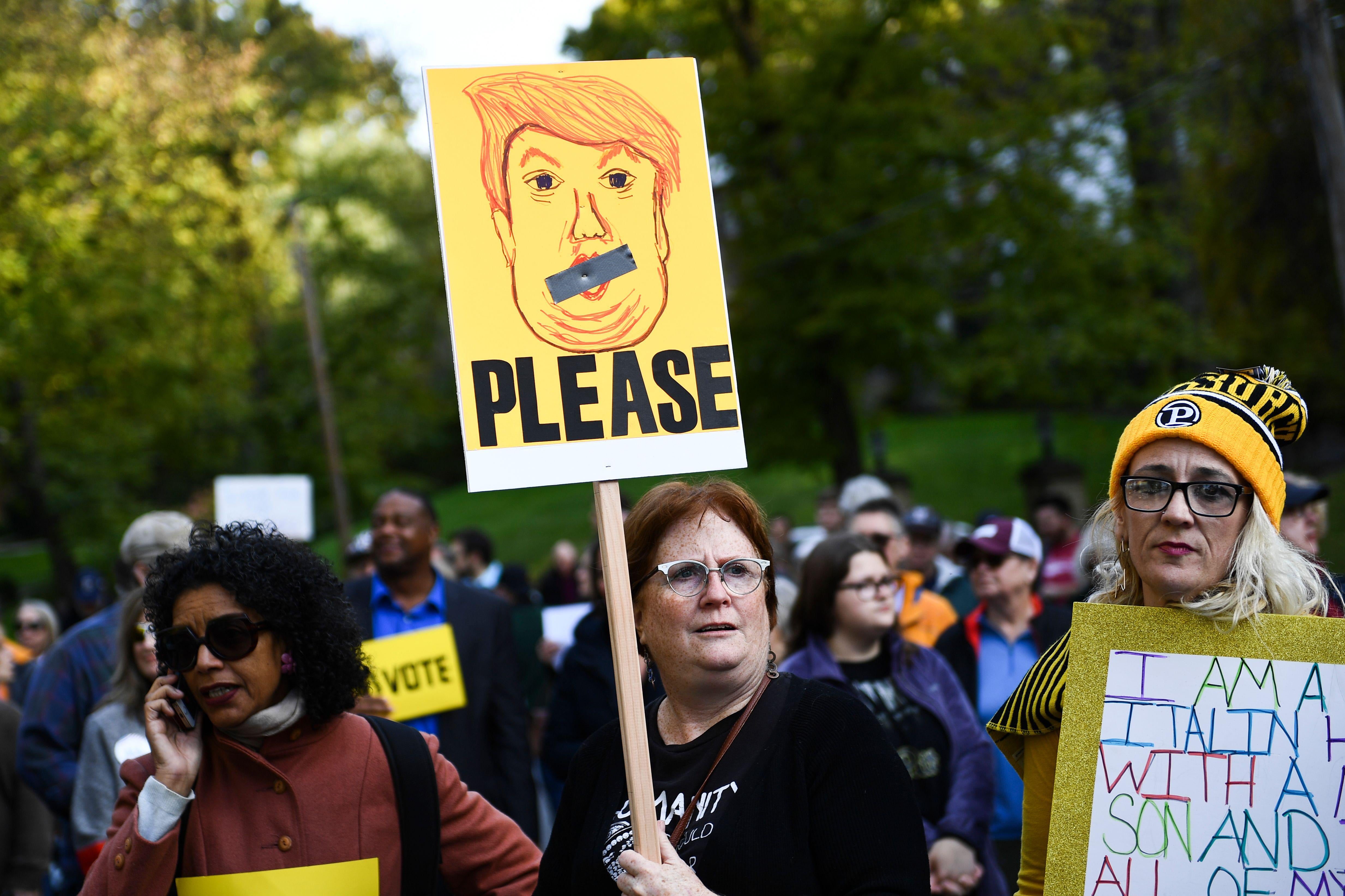 People protesting against US President Donald Trump wait near the Tree of Life Congregation on October 30, 2018 in Pittsburgh, Pennsylvania. - The first two victims of the deadliest anti-Semitic attack in recent US history were laid to rest in Pittsburgh on Tuesday as the grieving city awaits a controversial visit by President Donald Trump and his wife Melania.Trump's visit to the city has been contentious, coming amid a mounting row over whether his fierce rhetoric at campaign rallies and on Twitter has helped stoke extremism ahead of November 6 midterm elections. A protest in Pittsburgh against the president has been called for Tuesday afternoon. (Photo by Brendan Smialowski / AFP)        (Photo credit should read BRENDAN SMIALOWSKI/AFP/Getty Images)