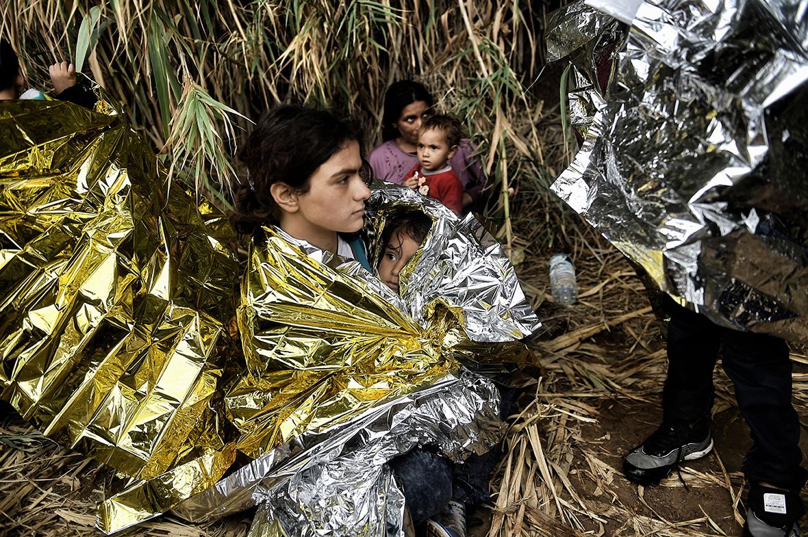 Syrian refugees cover up in metallic emergency blankets in Lesbos, Greece