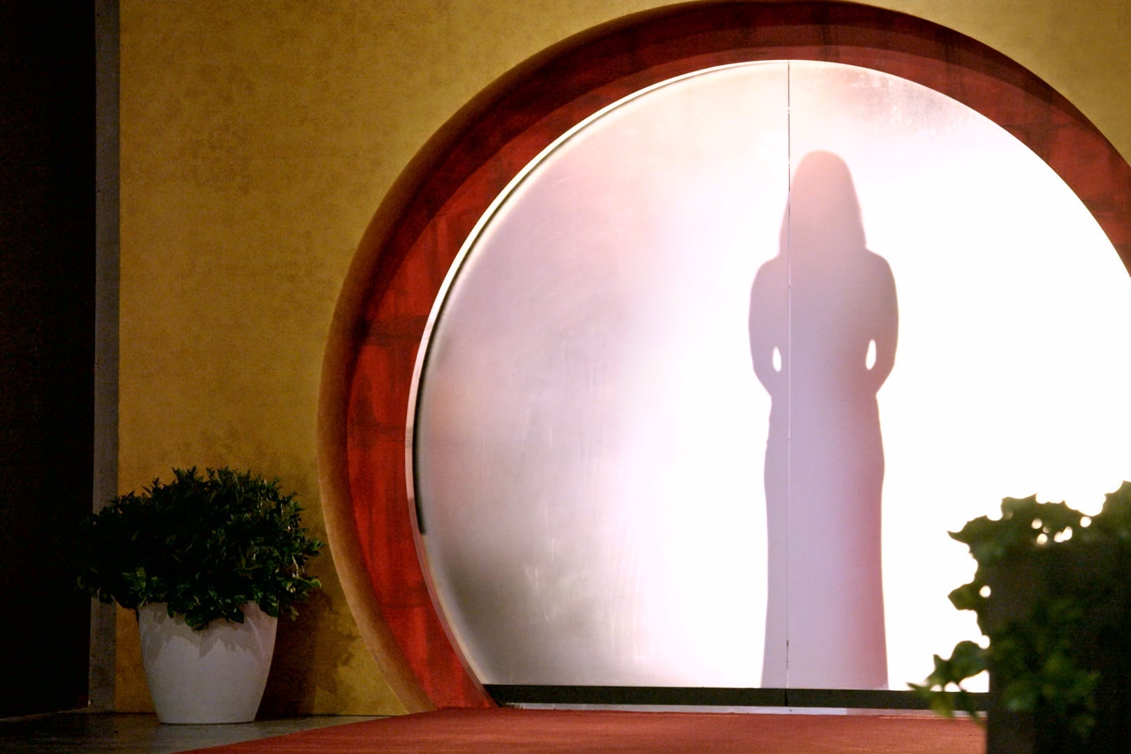 A female figure stands silhouetted in a smoky doorway.