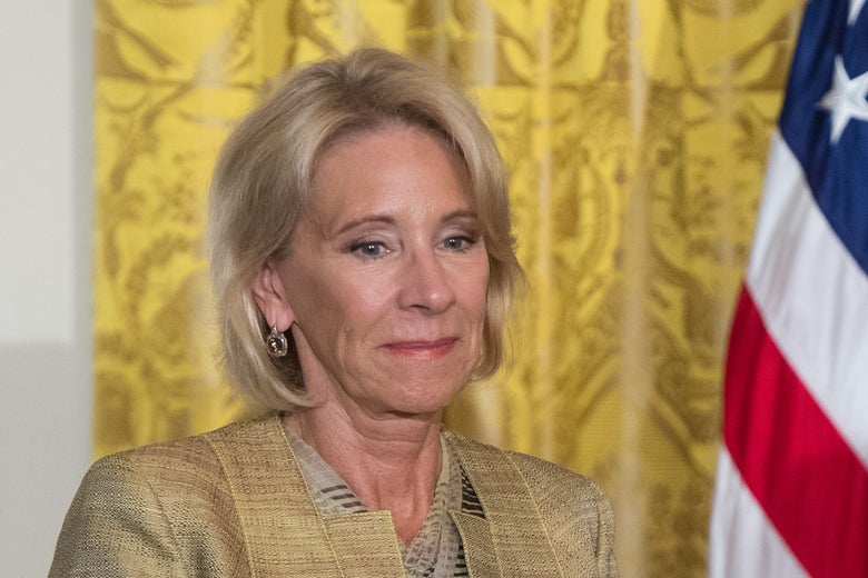 Betsy DeVos looks downward, as if upset about damage to her yacht.