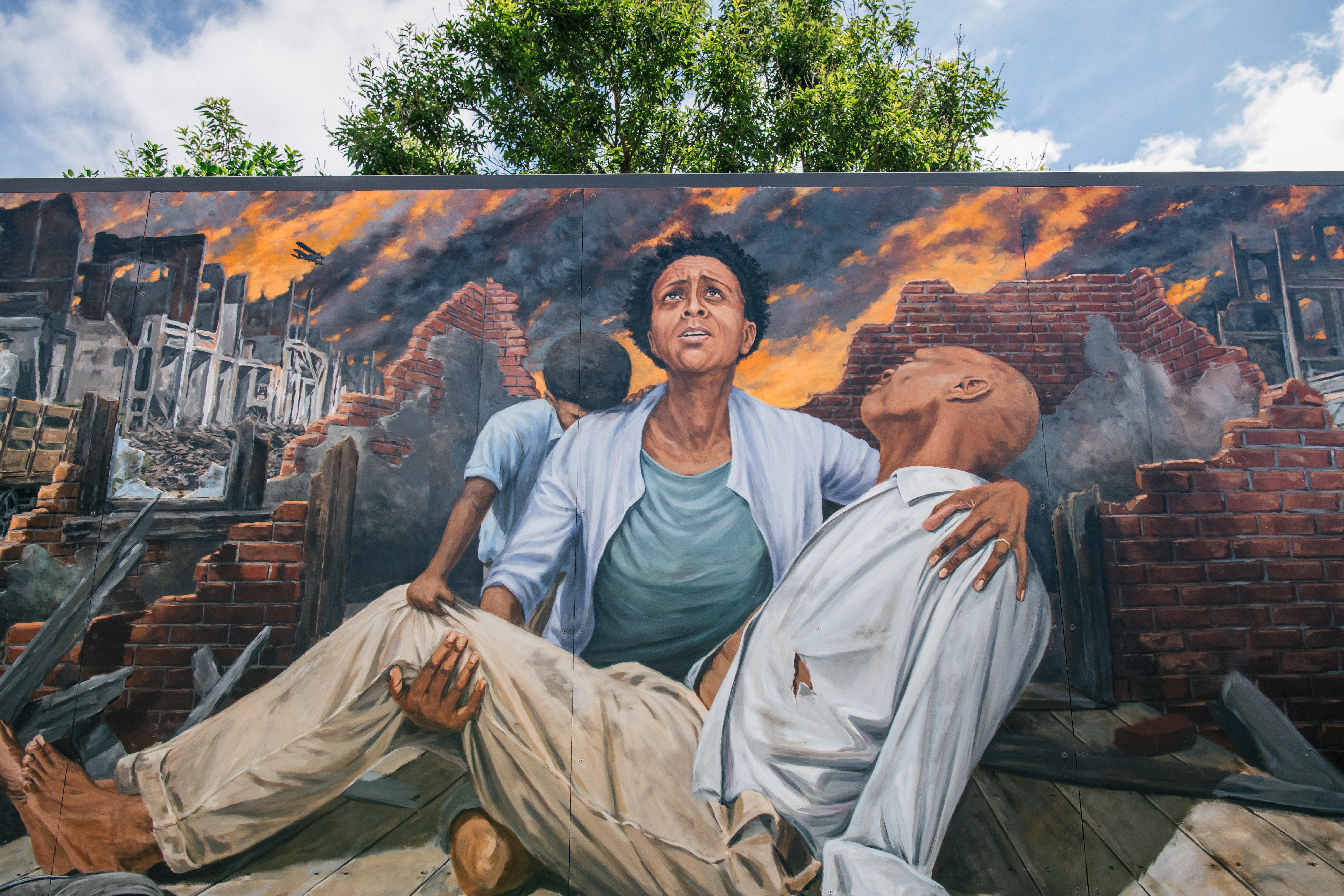 TULSA, OKLAHOMA - MAY 28 A mural depicting a woman and child holding a man during the Tulsa massacre.
