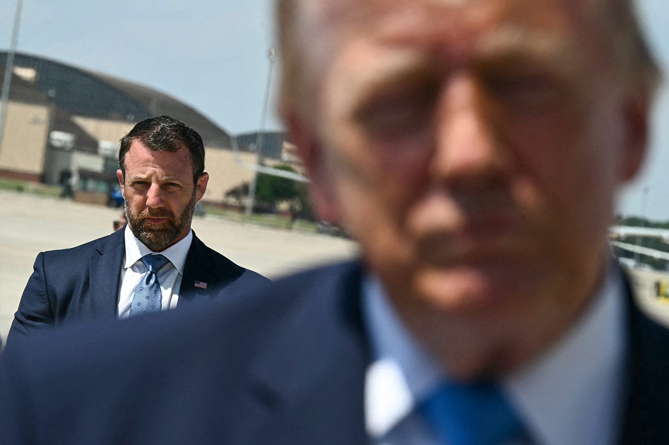 Trump is blurry in the foreground, Mullin is clear in the background.