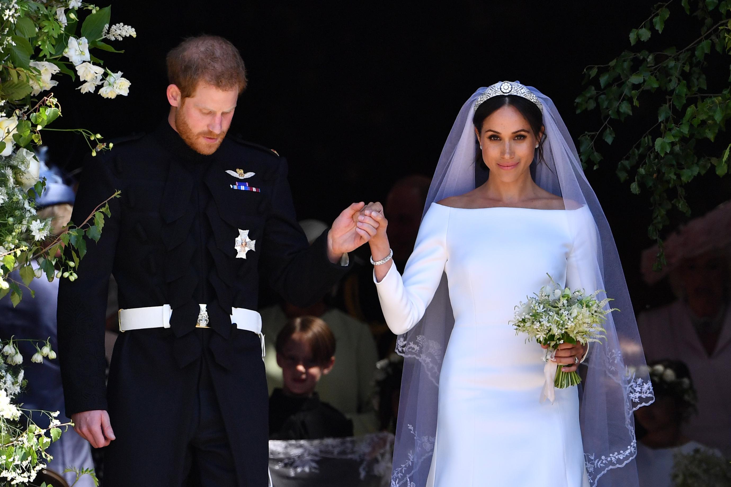 Prince Harry holds Meghan's hand as they emerge from the West Door of St George's Chapel, Windsor Castle, after their wedding ceremony.
