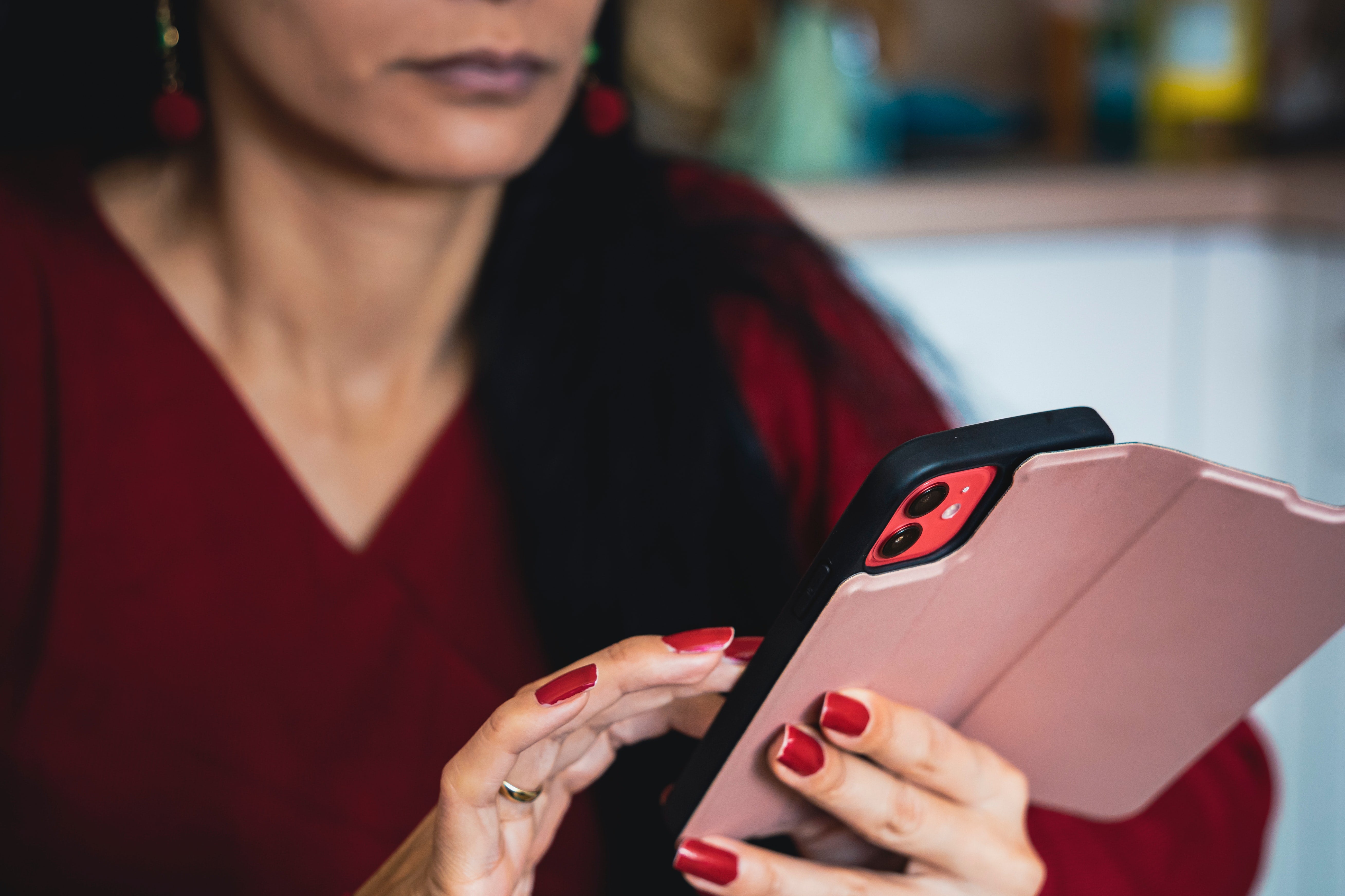 A woman, shown from the lips down, holds a smartphone.