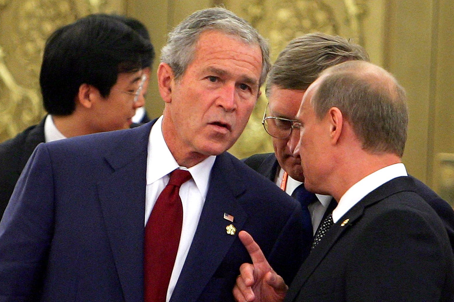 George W. Bush leans in to hear Vladimir Putin