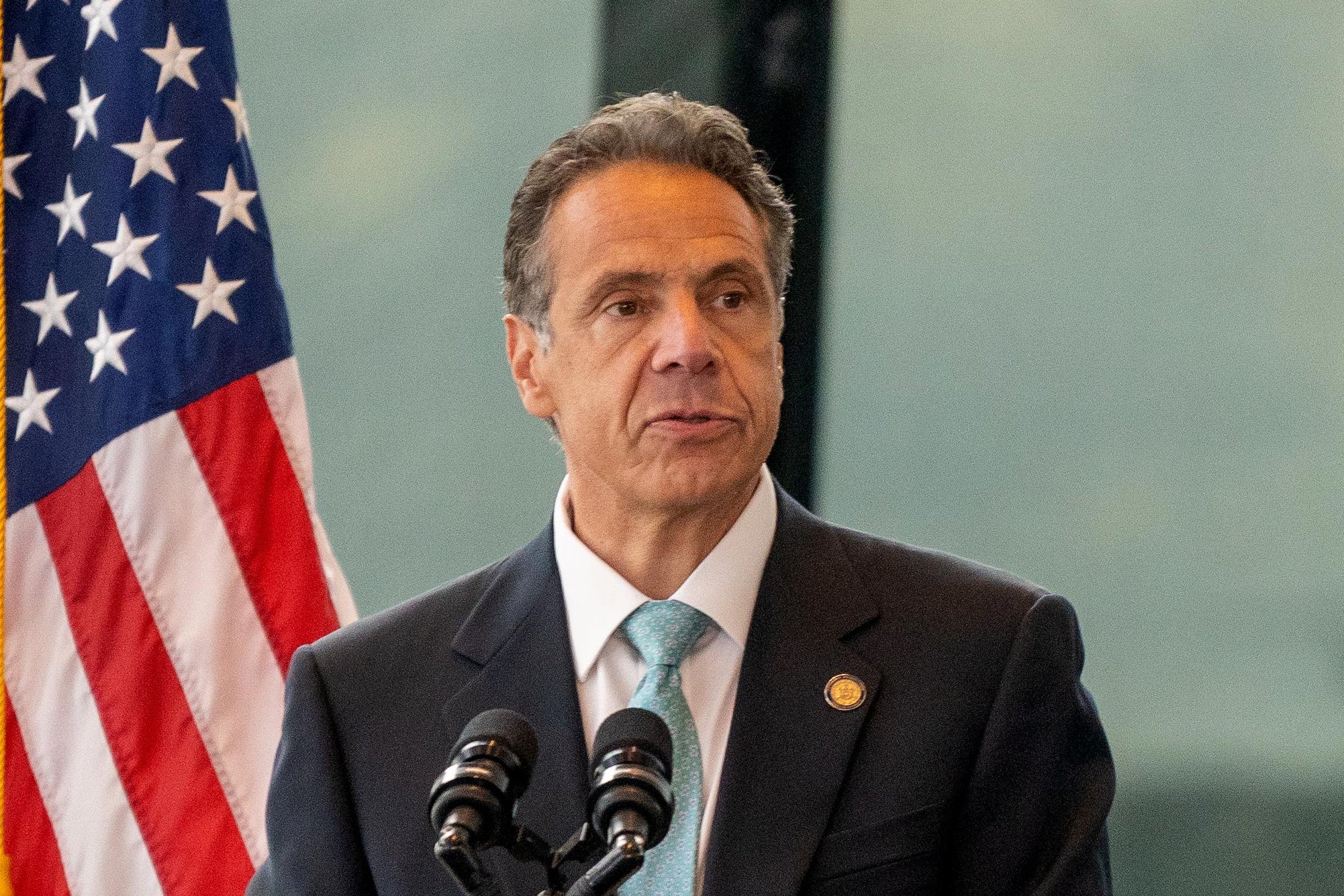 Andrew Cuomo speaking at a podium at One World Trade Center