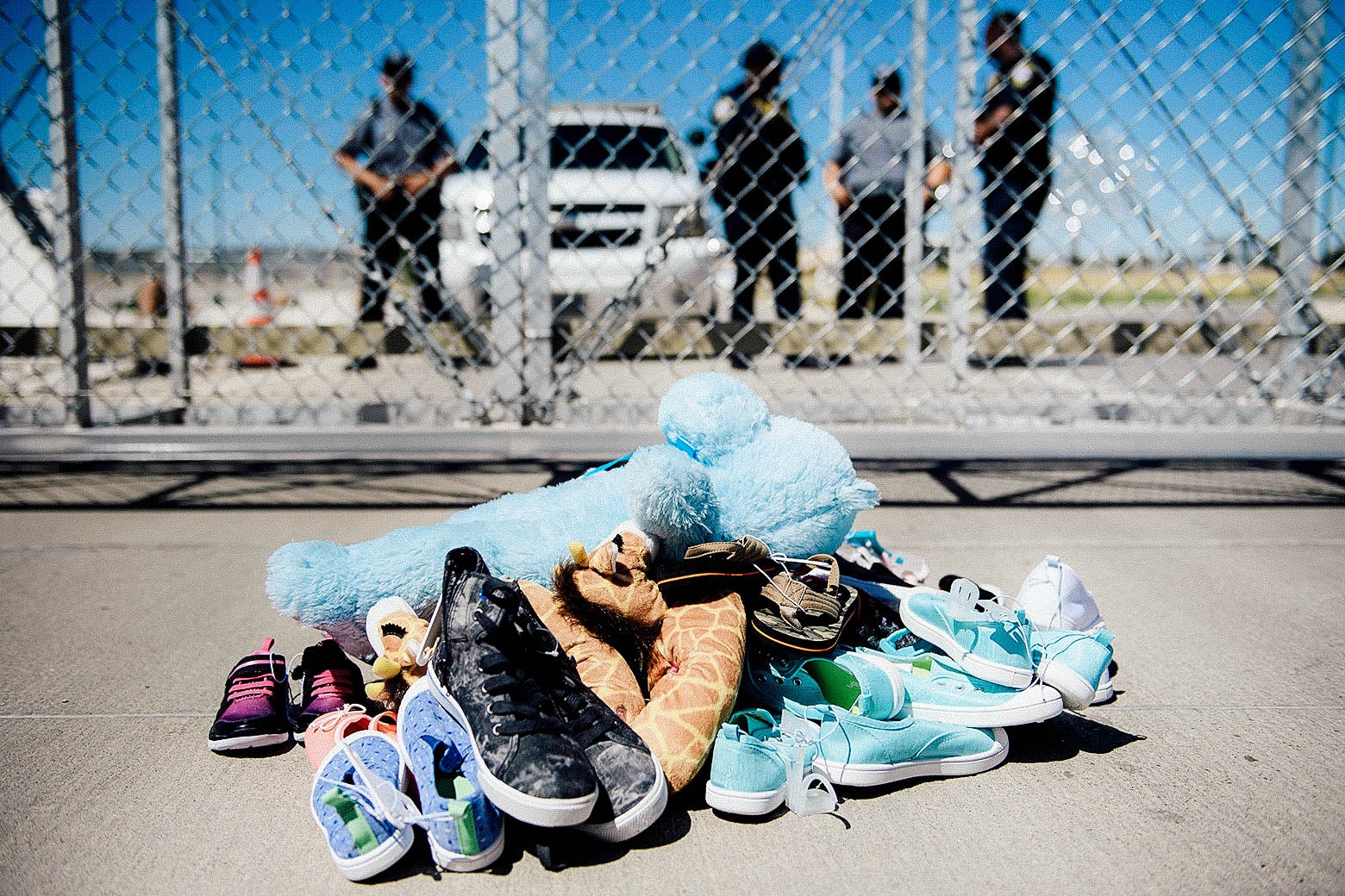 Security personnel stand before shoes and toys left at the Tornillo port of entry.