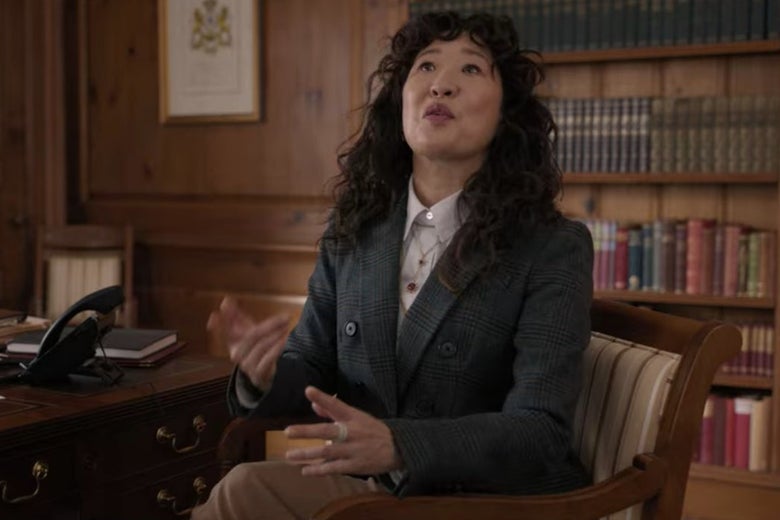 Dr. Kim sits in a chair in front of a bookshelf.