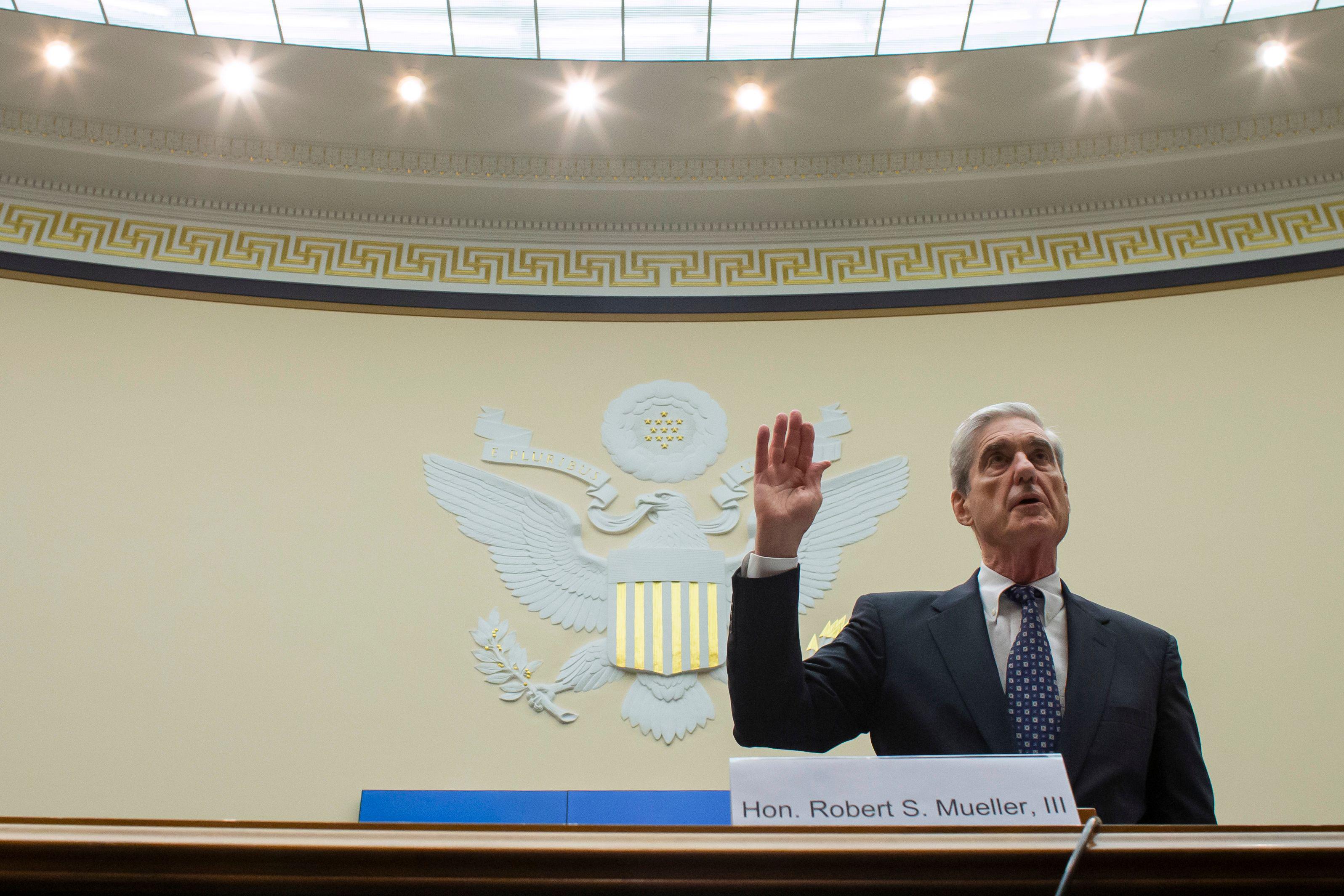 Robert Mueller stands, raising his right hand.