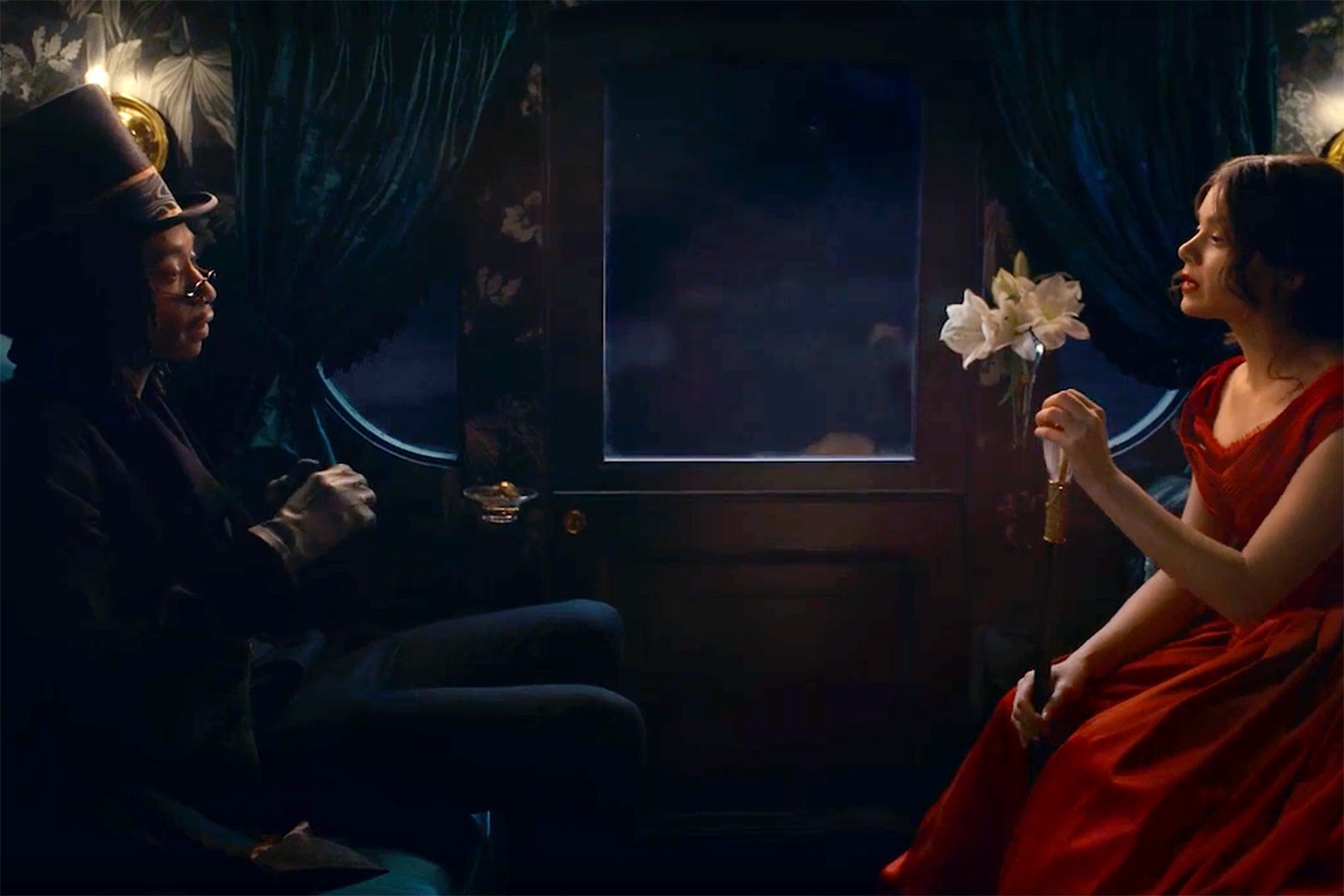 Wiz Khalifa as Death and Hailee Steinfeld as Emily Dickinson sitting across from each other in a carriage.
