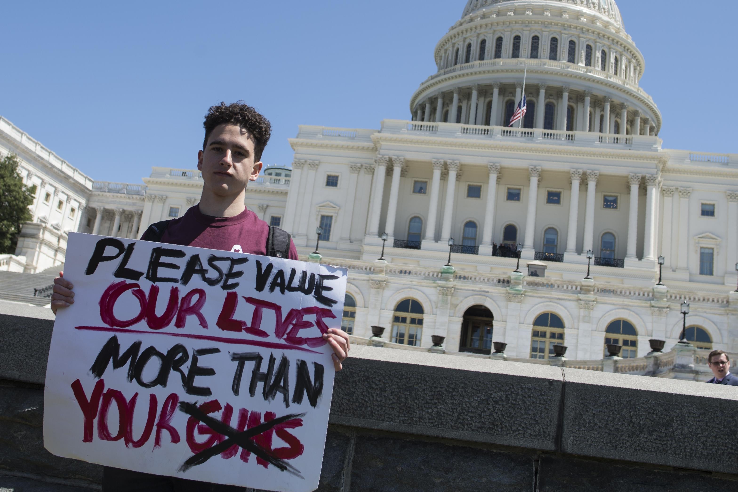 Amit Dadon, a graduate in 2017 from Marjory Stoneman Douglas High School, poses for a photo on the West Lawn of the US Capitol after rallying with several hundred fellow students to call for stricter gun laws in Washington, DC on April 20, 2018.