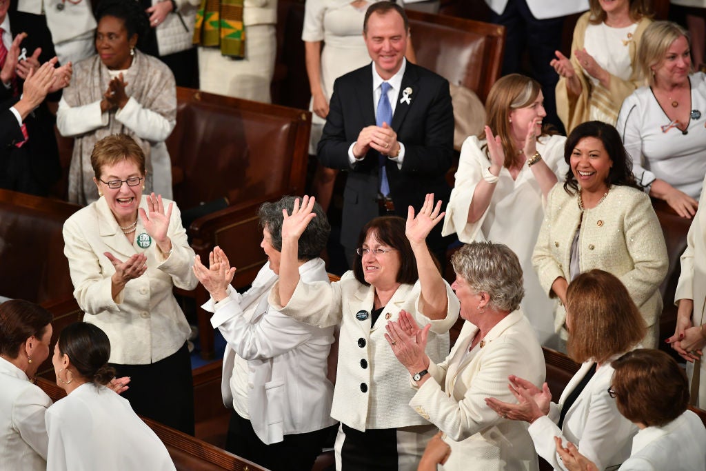 Kuster "raises the roof" as other congresswomen dressed in white laugh and cheer.