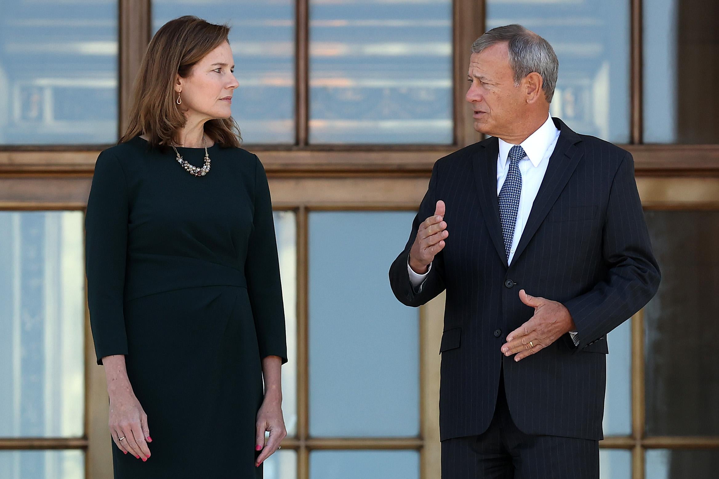 Amy Coney Barrett and John Roberts talk at the top of the Supreme Court’s marble steps.