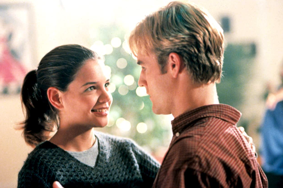 Katie Holmes and James Van Der Beek dance together, Holmes' faces the camera while Van Der Beek is in profile.