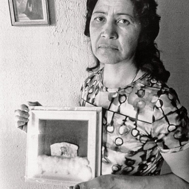 A woman holds up a frame.