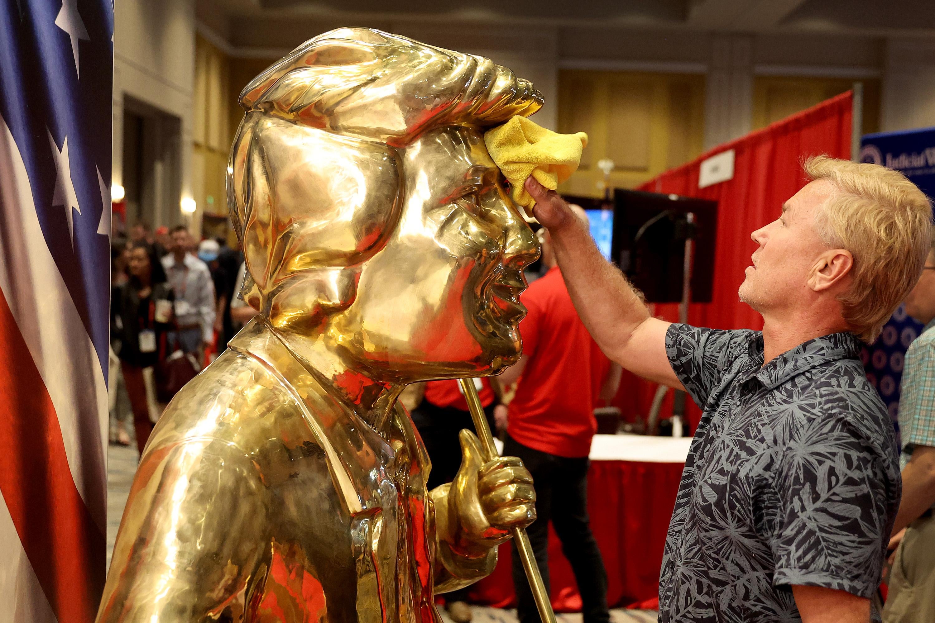 Artist Tom Zegan uses a cloth to wipe down the statue he created of former U.S. President Donald Trump at the Conservative Political Action Conference (CPAC) at The Rosen Shingle Creek on February 24, 2022 in Orlando, Florida. CPAC